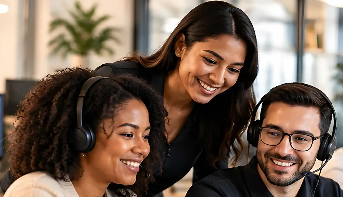 Three WorkRoute team members with headsets smiling together at a desk